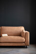 © vadim_fl - Comfortable sofa with pillows in the interior of a spacious living room, real photo with copy space on an empty black wall