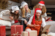 © ako-photography - group of women wearing Christmas hats make greeting video calls at Christmas time
