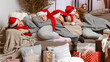 © ako-photography - four young womens in red santa hats fell asleep on the couch after wrapping Christmas presents
