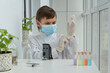 © Anna - Boy in mask puting on gloves before chemistry experiments with microscope, curiosity of young scientist, educational concept