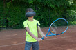 © Anna - Boy in glasses of virtual reality holding racquet and playing tennis with virtual trainer on ground court. Training process in new reality.