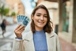 © Krakenimages.com - Young hispanic woman smiling happy holding polish zloty banknotes at the city