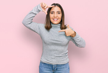 Sticker - Young beautiful woman wearing casual turtleneck sweater smiling making frame with hands and fingers with happy face. creativity and photography concept.