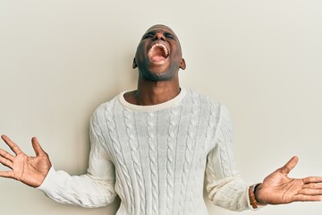 Young african american man wearing casual clothes celebrating mad and crazy for success with arms raised and closed eyes screaming excited. winner concept