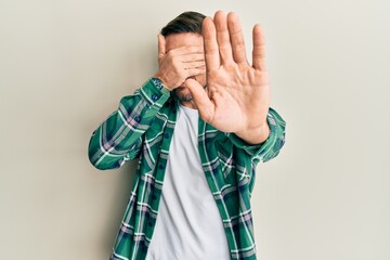 Wall Mural - Handsome man with beard wearing casual clothes covering eyes with hands and doing stop gesture with sad and fear expression. embarrassed and negative concept.