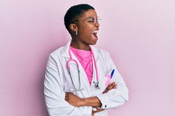 Sticker - Young african american woman wearing doctor uniform and stethoscope angry and mad screaming frustrated and furious, shouting with anger. rage and aggressive concept.