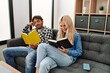© Krakenimages.com - Young couple smiling happy reading book sitting on the sofa at home.