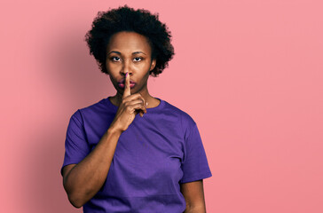 Poster - African american woman with afro hair wearing casual purple t shirt asking to be quiet with finger on lips. silence and secret concept.