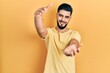 © Krakenimages.com - Handsome man with beard wearing casual yellow t shirt looking at the camera smiling with open arms for hug. cheerful expression embracing happiness.
