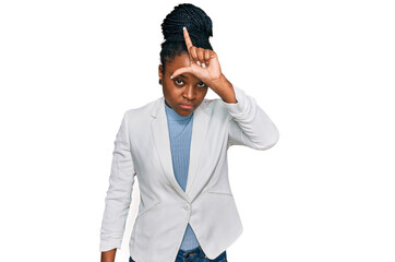 Sticker - Young african american woman wearing business clothes making fun of people with fingers on forehead doing loser gesture mocking and insulting.