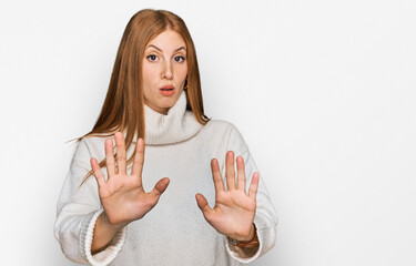 Young irish woman wearing casual winter sweater moving away hands palms showing refusal and denial with afraid and disgusting expression. stop and forbidden.