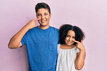 Poster - Young hispanic family of brother and sister wearing casual clothes together pointing with hand finger to face and nose, smiling cheerful. beauty concept