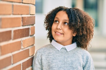 Sticker - Adorable hispanic student child girl smiling happy standing at the city.