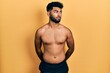 © Krakenimages.com - Arab man with beard wearing swimwear shirtless smiling looking to the side and staring away thinking.