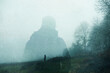 A double exposure of an atmospheric half transparent man looking at a person standing on the edge of a forest in the countryside. On a moody foggy winters day.