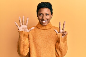 Wall Mural - Young african american girl wearing casual clothes showing and pointing up with fingers number eight while smiling confident and happy.