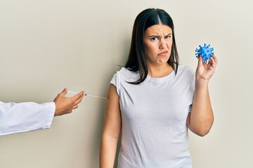 Sticker - Beautiful brunette woman getting vaccine holding coronavirus toy skeptic and nervous, frowning upset because of problem. negative person.