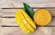 Mango smoothie in a glass and mango on wooden background.Mango shake.Tropical fruit concept.