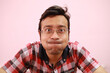 Funny Indian man suppressing his laughter isolated on a pink background