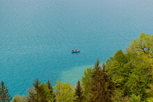 Beautiful Landscape Of The Tranquil Blue Lake With Fishermen In A Boat