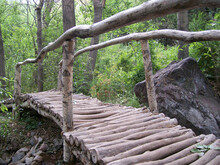 Wooden Bridge Over The River For The Passage In The Mountains 