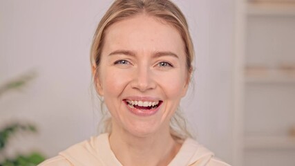 Poster - portrait laughing looking camera young caucasian joyful woman with blond hair wearing casual hoodie posing indoors