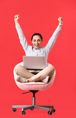Happy female programmer with laptop on color background