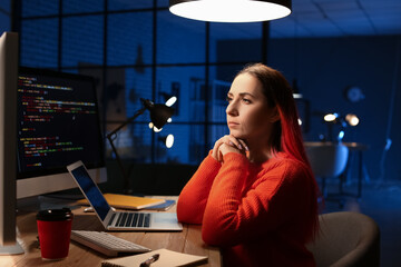 Wall Mural - Female programmer working with computer in office at night