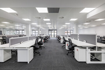 modern corporate open office in minimalist modern design in whites and greys, empty office workstati