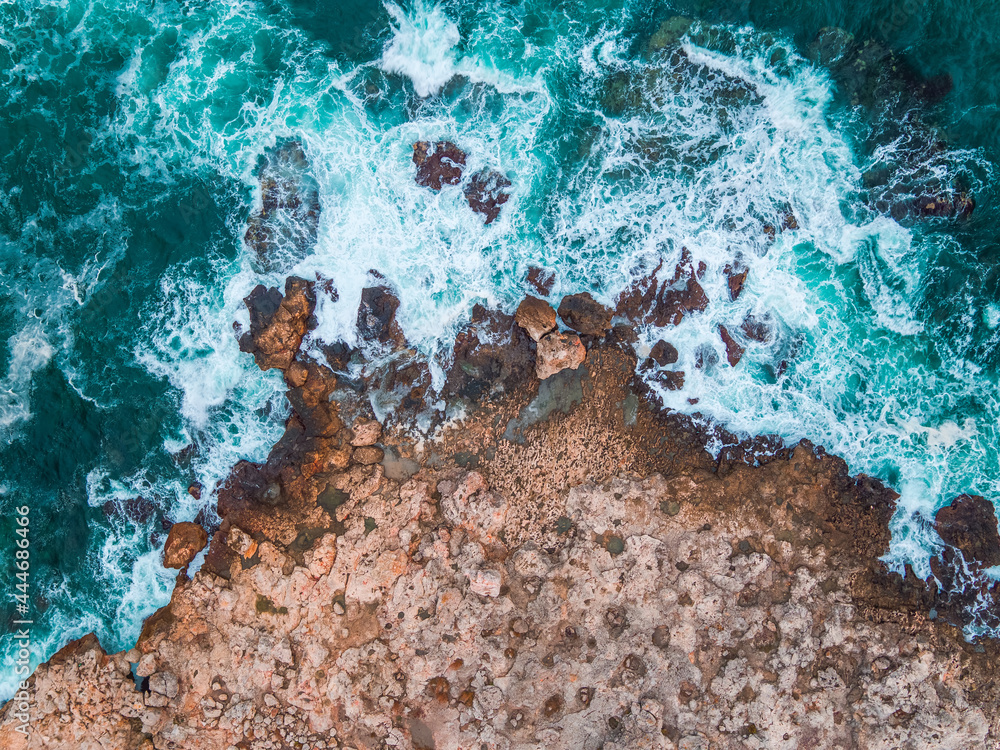 Aerial view of rocky coastline and crashing waves - obrazy, fototapety, plakaty 