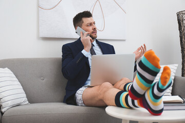 Poster - Businessman in shirt, underwear and funny socks talking on phone during video call at home