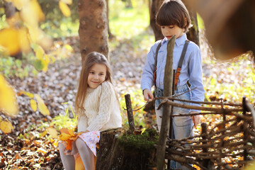 Young family on a walk in the autumn park on a sunny day. Happiness to be together.