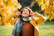 Joyful young woman laughing in autumn park