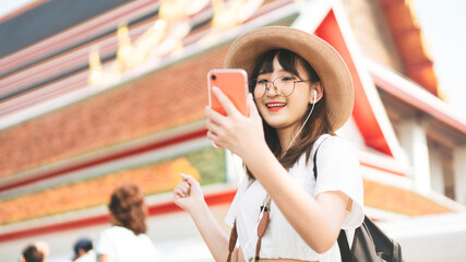 young adult tourist asian woman using smart phone for listen music application.
