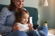 © kegfire - Mother and child watching cartoon together on smartphone