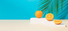 Modern Still Life With Fresh And Ripe Orange Fruit On Podium Or Pedestal On A Blue Background With Tropical Palm Leaf. Minimal Detox Diet Or Summer Concept. Copy Space.