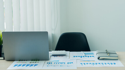 on the desk of a businessman with a laptop and a calculator with graphs