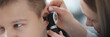Otorhinolaryngologist examining ear of sick man with otoscope closeup