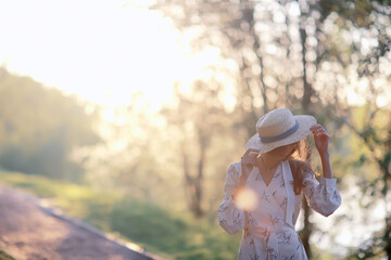 Wall Mural - happy romantic girl in a straw hat / young model in a dress summer day, happiness woman