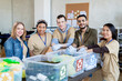 © pressmaster - Team of multiracial volunteers standing by table with plastic containers