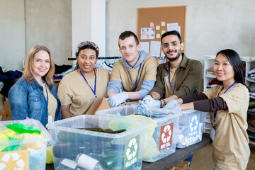 Wall Mural - Team of multiracial volunteers standing by table with plastic containers