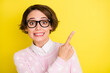 Photo portrait amazed funny girl in glasses pointing finger empty space isolated vibrant yellow color background