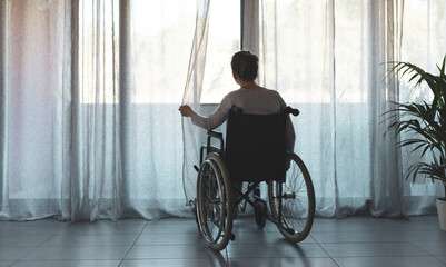 Woman in wheelchair at home alone