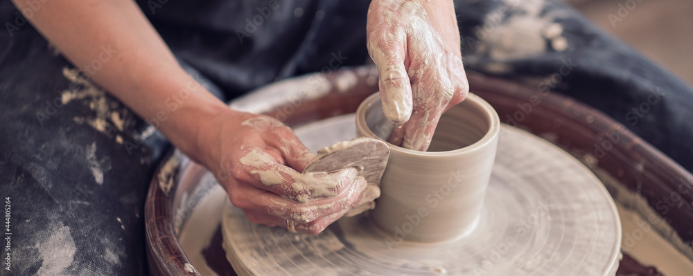 Close up female hands make dishes from clay. woman hands working on potters wheel. The master potter works in a workshop. banner - obrazy, fototapety, plakaty 
