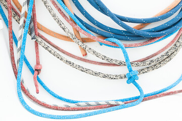 Multicolored ropes with knots on a white background close-up.