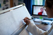 © Martin Barraud/Caia Image - Female architect video conferencing and working at drafting table