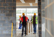 © Paul Bradbury/Caia Image - Construction workers carrying wood frame at construction site