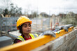 © Paul Bradbury/Caia Image - Female construction worker using level tool on brick wall