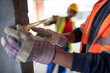 © Paul Bradbury/Caia Image - Close up construction workers using tape measure