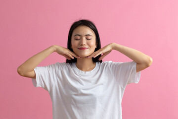 Close up portrait of young asian woman doing facebuilding yoga face gymnastics yoga massage.